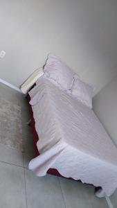 a bed with white sheets and pillows in a room at Casa COP 30 in Belém