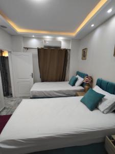 a bedroom with two beds and a door at Oasis marina الاحياء in Hurghada +3 photos