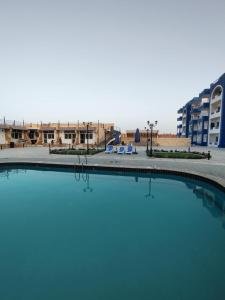 a pool of water in front of a building at Oasis marina الاحياء in Hurghada