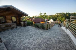 a large patio in front of a log cabin at Casa Alexia in Potoc