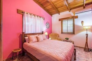 a bedroom with pink walls and a bed and a chair at Stylish Colorful & Cozy Tropical Private Bedroom in Herradura +41 photos