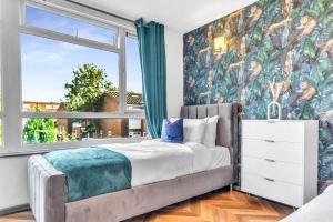 une chambre avec un lit avec une grande fenêtre dans l'établissement Large 4 Bedroom House - Sleeps 10 - Birmingham City Centre - Perfect for Work, Families, Groups, Business Travellers & Contractors - FREE PARKING - By 02 Academy, Bullring, Newstreet, Selfridges - SMART TVs in all rooms, à Birmingham