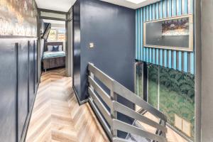 un couloir avec des murs bleus et un escalier avec un lit dans l'établissement Large 4 Bedroom House - Sleeps 10 - Birmingham City Centre - Perfect for Work, Families, Groups, Business Travellers & Contractors - FREE PARKING - By 02 Academy, Bullring, Newstreet, Selfridges - SMART TVs in all rooms, à Birmingham 18 autres photos