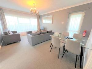 ein Wohnzimmer mit einer Couch und einem Tisch und Stühlen in der Unterkunft Dog Friendly Chalet With Outdoor Seating At Broadland Park And Marina Ref 12050B in Lowestoft