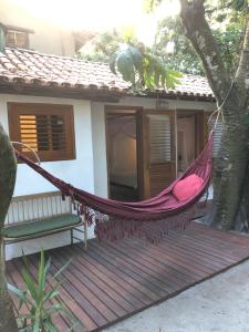 a hammock on a porch of a house at Suite Jenipapo Caraiva in Caraíva