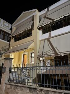 a white building with a balcony with a fence at Central Aegina Apartment in Aegina Town