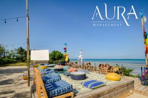 ein langer Tisch mit Stühlen und ein Strand in der Unterkunft Aura Space Apartments & Villas Fumba Town Zanzibar in Dambani