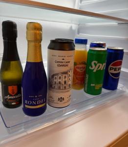 a refrigerator filled with bottles of beer and condiments at Chmielna 2025 Premium Apartment Wyspa Spichrzów in Gdańsk