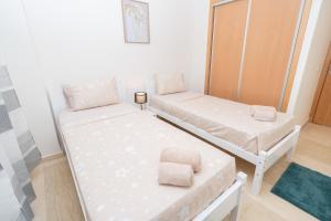 タンジェにあるCocon neuf & cosy 2 ch, clim, wifi, idéal familleのベッド2台と鏡のある小さな部屋