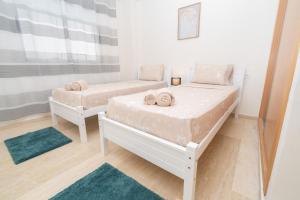 タンジェにあるCocon neuf & cosy 2 ch, clim, wifi, idéal familleのベッドが2つと窓のある部屋