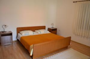 una camera con un grande letto e due comodini di Apartments Ana a Baška