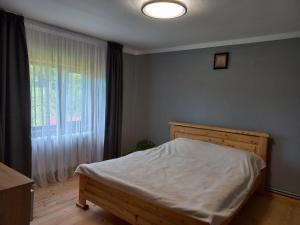 a bedroom with a bed and a window at Садиба Стожари in Vorokhta