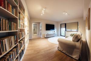 a living room with a couch and shelves of books at Apartament Plaza - Self Check-in in Gura Humorului