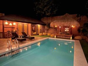 a swimming pool in front of a house at night at Nelson villa home in Caticlan