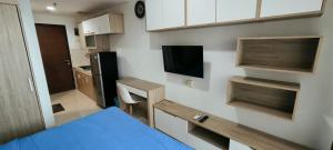 a small room with a blue bed and a kitchen at Springwood Tranquil Studio in Warungmangga
