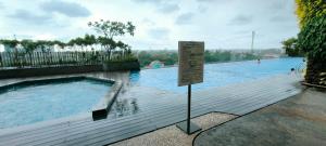 a sign in front of a swimming pool at Springwood Tranquil Studio in Warungmangga