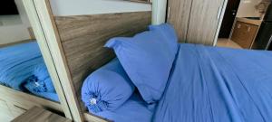 a bunk bed with blue pillows on it at Springwood Tranquil Studio in Warungmangga