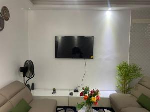 Una sala de estar con un televisor en una pared blanca. en Havre de Paix au Centre de Dakar, en Dakar 10 fotos más