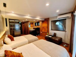 東京にあるB2 Shinjuku Business District hotel, 9 mins to ST Max 4P 新宿商务区 全新装修 交通中心 车站9分钟 最大4人 直达新宿 涉谷 表参道 品川 池袋 上野 代代木 银座 原宿のベッド2台とソファがあるホテルの部屋