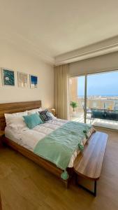 une chambre avec un grand lit et une grande fenêtre dans l'établissement Taghazout Bay Getaway Beach, à Taghazout