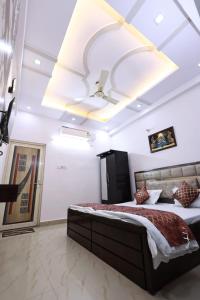 a bedroom with a large bed and a ceiling at Mahadev P Guest House in Varanasi
