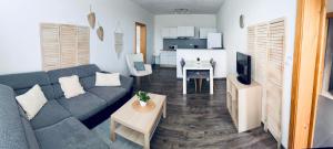 a living room with a couch and a table and a kitchen at Apartmán Lilly in Borovany