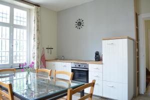 a kitchen with a glass table in a kitchen at Château de la Motte in Yvoir