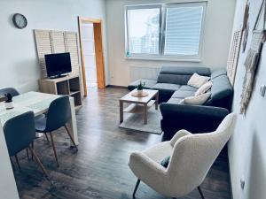 a living room with a couch and a table and chairs at Apartmán Lilly in Borovany