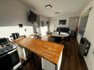 a kitchen and living room with a table and a stove at Buenavista Chalten, Casa de Montaña in El Chalten