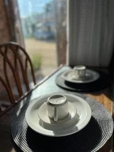 una mesa con dos platos en la parte superior de una mesa en Suíte com Ventilador e cozinha, en São Pedro da Aldeia