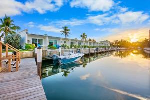 马拉松椰树沙洲度假村的停靠在有房屋的码头旁边的船