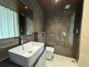 un bagno con lavandino, doccia e WC di Hotel Ganga Aamantran a Haridwār Altre 32 foto