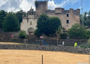 eine alte Burg hinter einer Steinmauer in der Unterkunft Mons resort in Le Puy en Velay