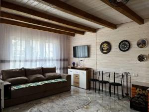 a living room with a couch and a table at Карпатська Тиша in Utoropy