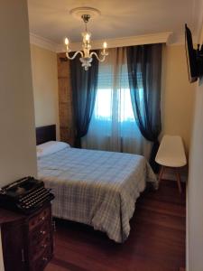 a bedroom with a bed and a window with blue curtains at CA Cantábrico a la vista, frescor a tu alcance in Santander