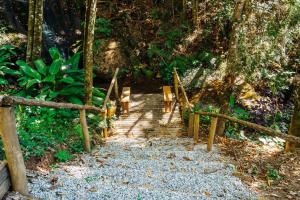 a wooden path through a forest with a wooden fence at Pousada O Bosque in Joanópolis +97 photos