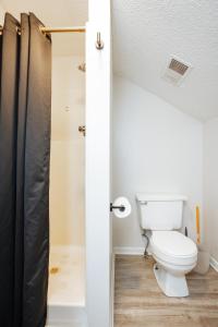 a bathroom with a toilet and a shower at Private Suite Near It All - Prime Location in Lees Summit