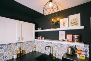 a kitchen with blue and white tiles and a sink at Cotroceni Accommodations House in Bucharest