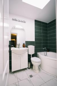 a bathroom with a toilet and a tub and a sink at Cotroceni Accommodations House in Bucharest