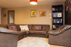 a living room with a brown couch and a book shelf at Cotroceni Accommodations House in Bucharest