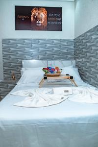 een wit bed met een dienblad erop bij Alo viajante in Sorocaba +19 foto's