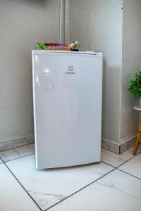 een witte koelkast op de vloer naast een muur bij Alo viajante in Sorocaba