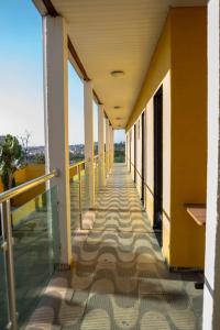 een lege gang van een gebouw met gele muren en ramen bij Alo viajante in Sorocaba