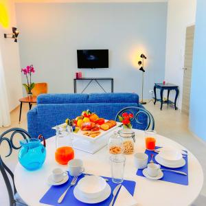 una mesa blanca con una bandeja de fruta. en L'Ancora appartamenti 2, en Giovinazzo