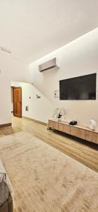 a living room with a large flat screen tv on the wall at Modern & Comfy Studio-AlGhub 13 in Ras al Khaimah