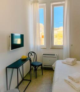 Habitación con 2 camas, mesa y TV. en L'Ancora appartamenti 2, en Giovinazzo 37 fotos más