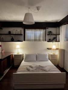 a bedroom with a bed with two lamps and two tables at Vintage Studio - Great for Travelers in Transit in Koropíon