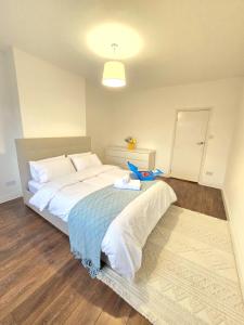 Un dormitorio con una cama con un animal de peluche encima. en 2bedroom sleeps 5 Raynes Park London 30min to Central London Family Friendly, en Raynes Park