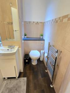Un baño con un inodoro blanco y un lavabo. en 2bedroom sleeps 5 Raynes Park London 30min to Central London Family Friendly, en Raynes Park