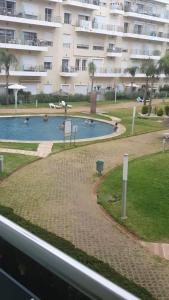 a swimming pool in front of a large building at Résidence kettani in Zemmour Touirza